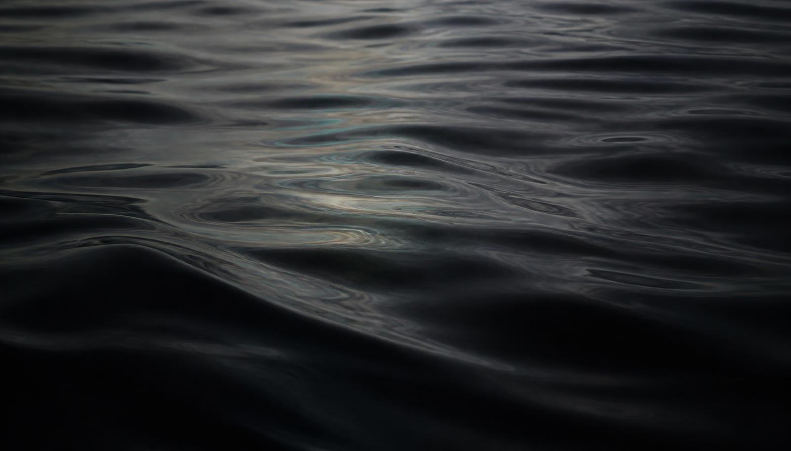 Abstract dark ocean surface with subtle turquoise sheen